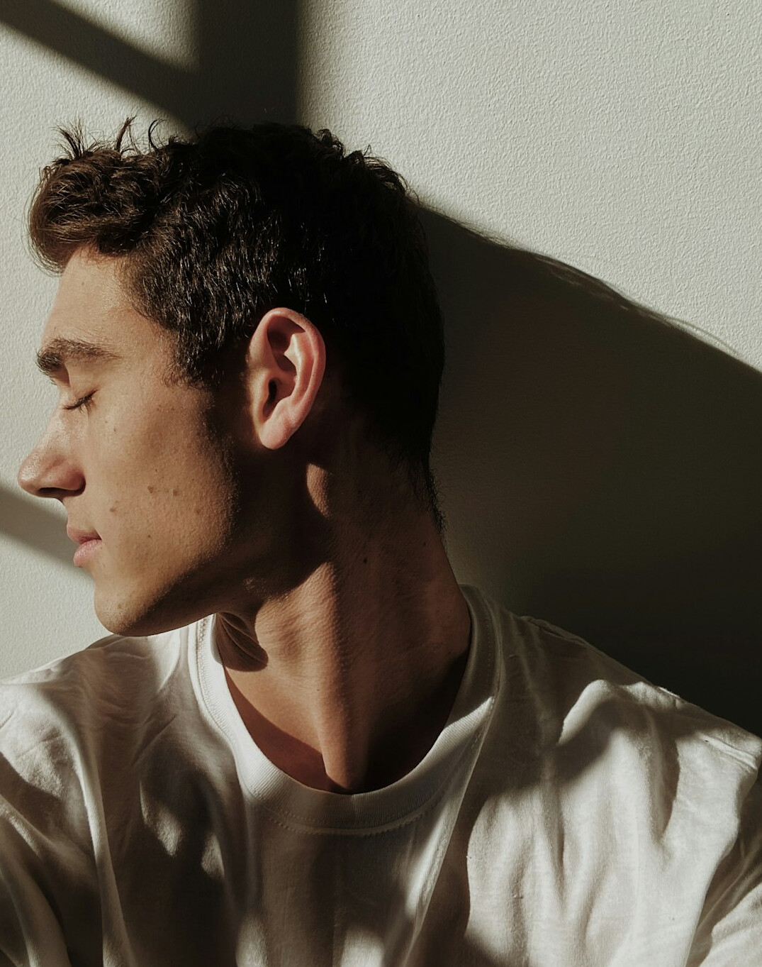 Man with short dark hair in a white shirt